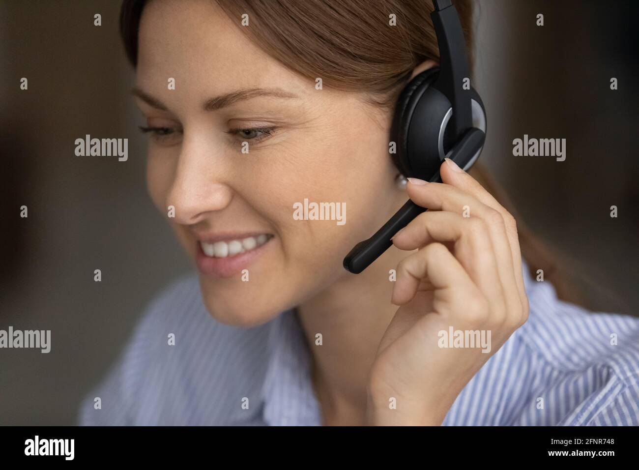 Jeune femme responsable du centre d'appels dans le micro-casque/l'oreillette prenant l'appel du client Banque D'Images