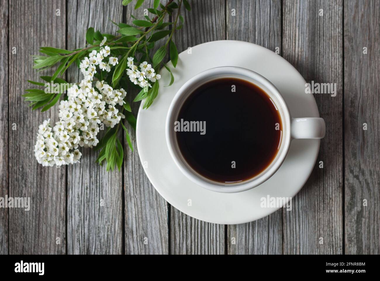 Tasse de café avec fleurs printanières sur une table en bois, photo en grand angle Banque D'Images