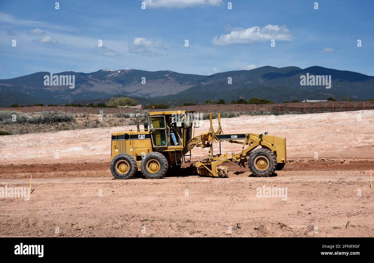 Un conducteur d'équipement lourd utilise une niveleuse Caterpillar 120H pour déplacer la terre sur un chantier de construction de routes à Santa Fe, Nouveau-Mexique. Banque D'Images