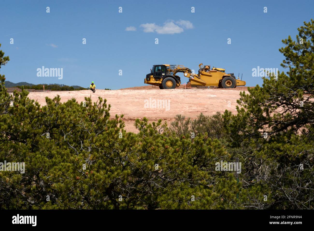 Un conducteur d'équipement lourd utilise une décapeuse automotrice 623H Caterpillar pour éliminer la saleté sur le chantier d'amélioration sur autoroute de Santa Fe, Nouveau-Mexique. Banque D'Images