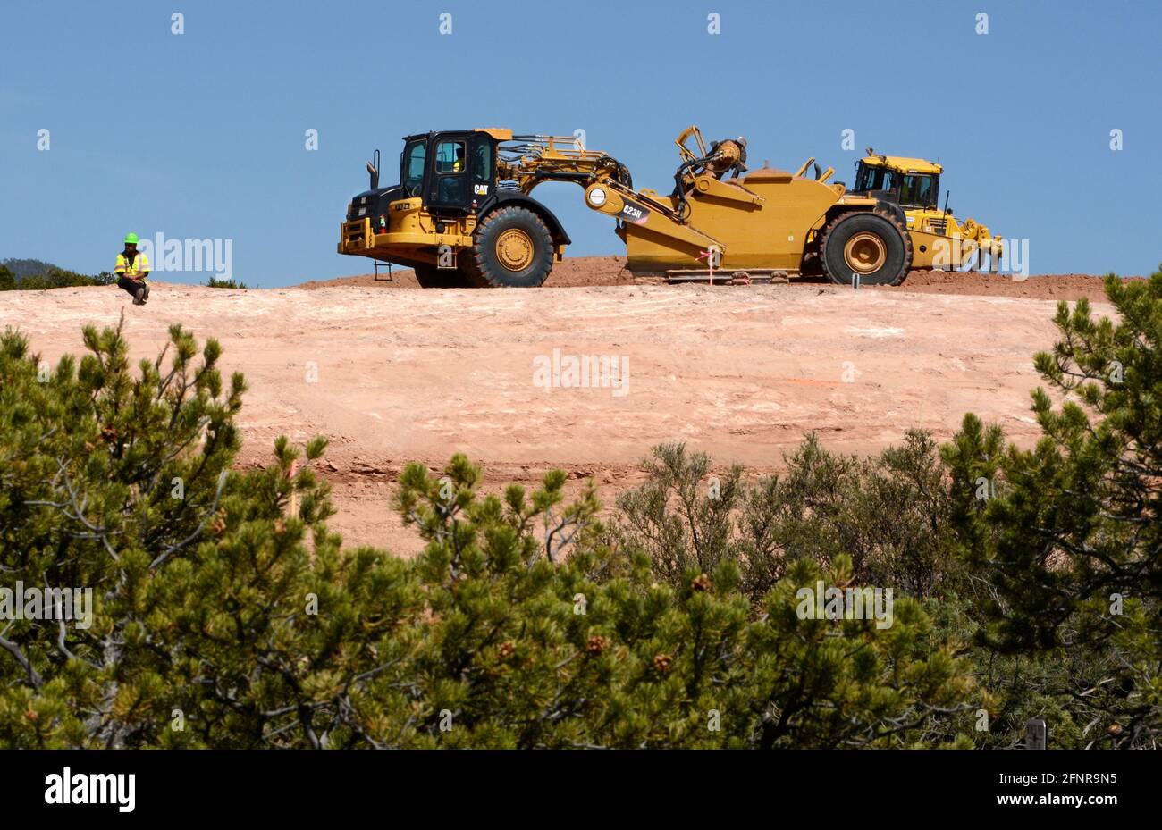 Un conducteur d'équipement lourd utilise une décapeuse automotrice 623H Caterpillar pour éliminer la saleté sur le chantier d'amélioration sur autoroute de Santa Fe, Nouveau-Mexique. Banque D'Images