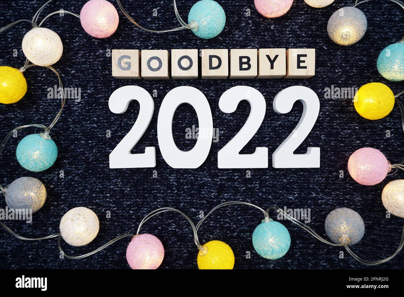Adieu 2022 lettre de l'alphabet décorer avec boule de coton LED sur fond de tissu tricoté bleu Banque D'Images
