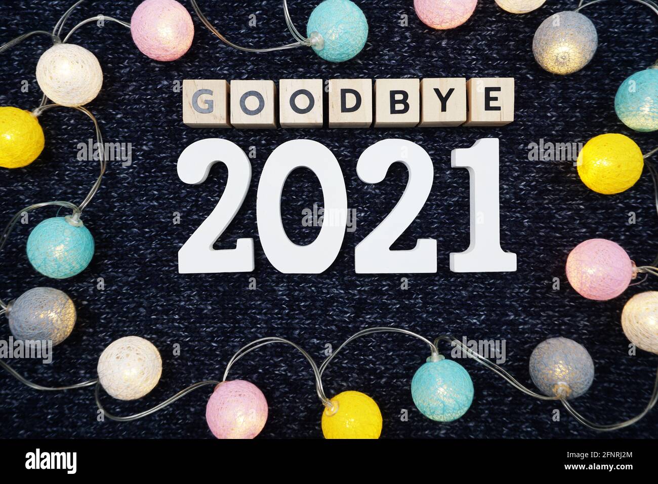 Adieu 2021 lettre de l'alphabet décorer avec boule de coton LED sur fond de tissu tricoté bleu Banque D'Images