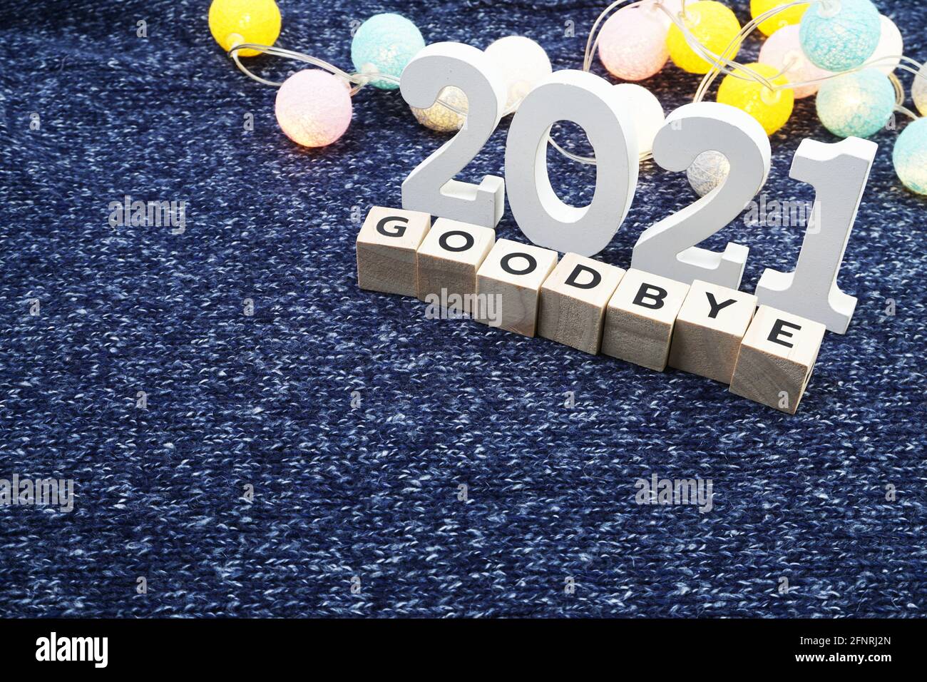 Adieu 2021 lettre de l'alphabet décorer avec boule de coton LED sur fond de tissu tricoté bleu Banque D'Images