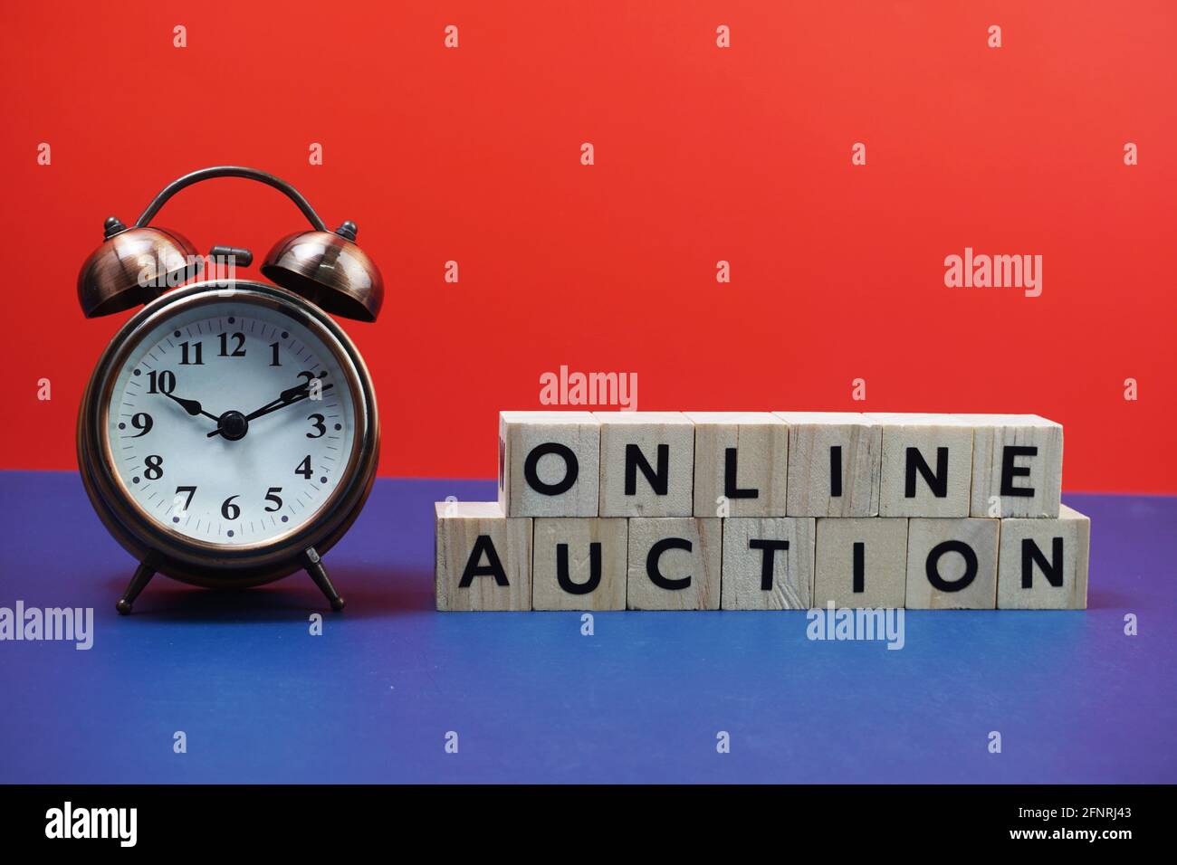 Lettre alphabet de vente aux enchères en ligne avec réveil sur fond bleu et rouge Banque D'Images