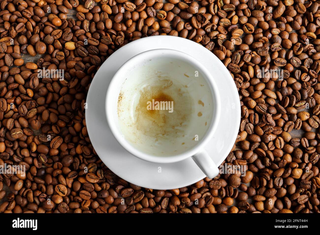 Videz le fond de la tasse à café et des grains de café. Vue de dessus. Copier l'espace. Banque D'Images