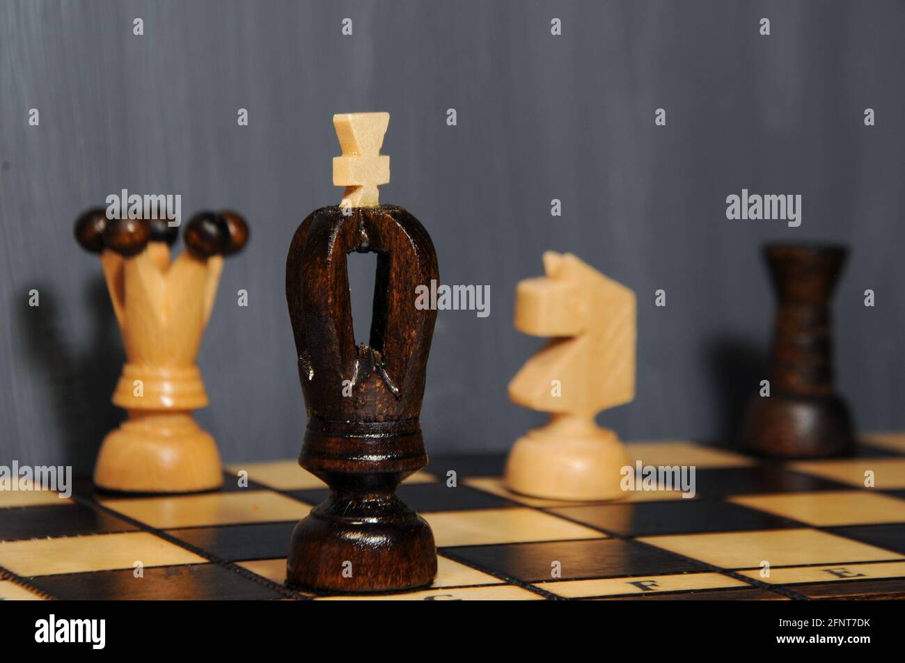 Pièces d'échecs - roi, reine, rook et chevalier sur un échiquier en bois sur fond gris. Passe-temps intérieur Banque D'Images