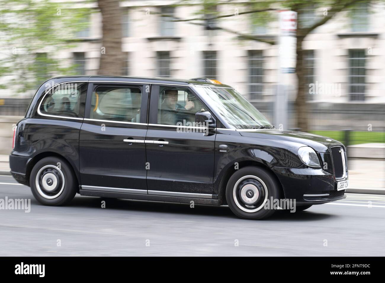 Un taxi noir londonien longeant Whitehall, Westminster, Londres, Royaume-Uni Banque D'Images
