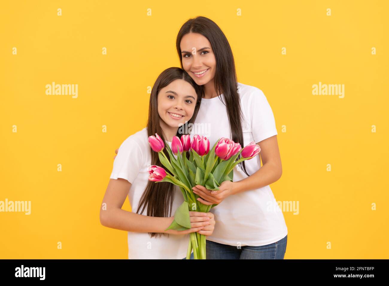 Fille heureuse fille et mère tiennent le bouquet de fleurs de tulipe de printemps pour les vacances du 8 mars, fête des femmes Banque D'Images