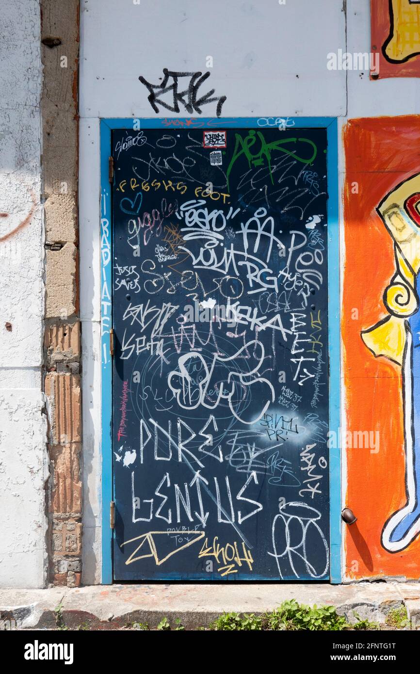 VANDALISME OU ART ? Une porte à Coney Island avec de multiples étiquettes et graffiti. À Brooklyn, New York. Banque D'Images