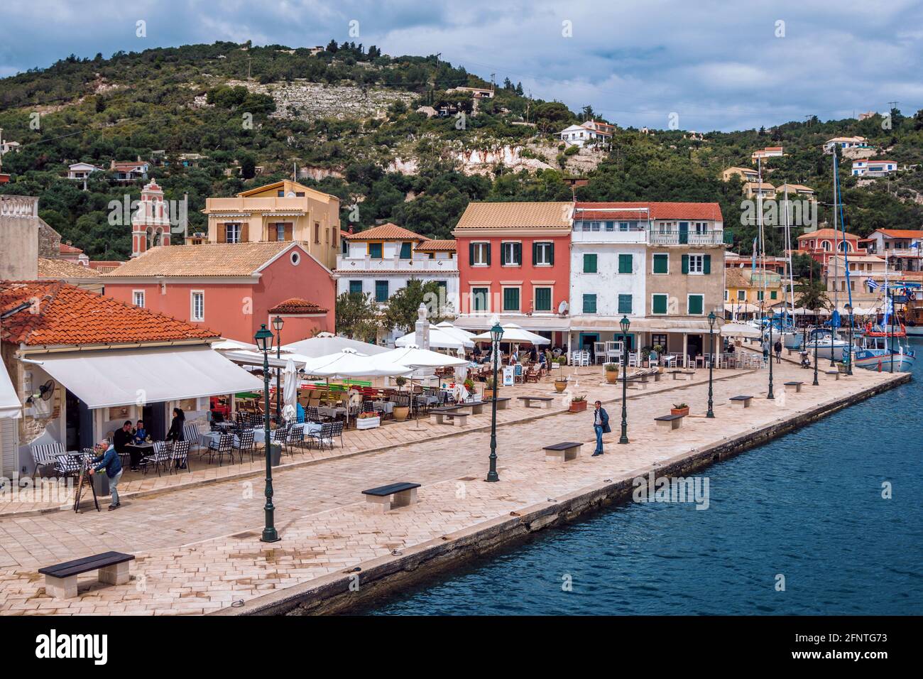 Ile de Paxos/Grèce- 7 mai 2019: Vue sur le magnifique port de Loggos - baie de mer avec l'eau turquoise calme, les navires et les yachts vieilles maisons colorées, ciel bleu Banque D'Images