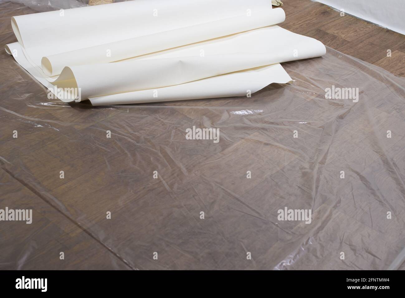 Rouleaux de papier peint blanc sur le sol pendant la rénovation. Collage du papier peint, placement pour le texte. Banque D'Images