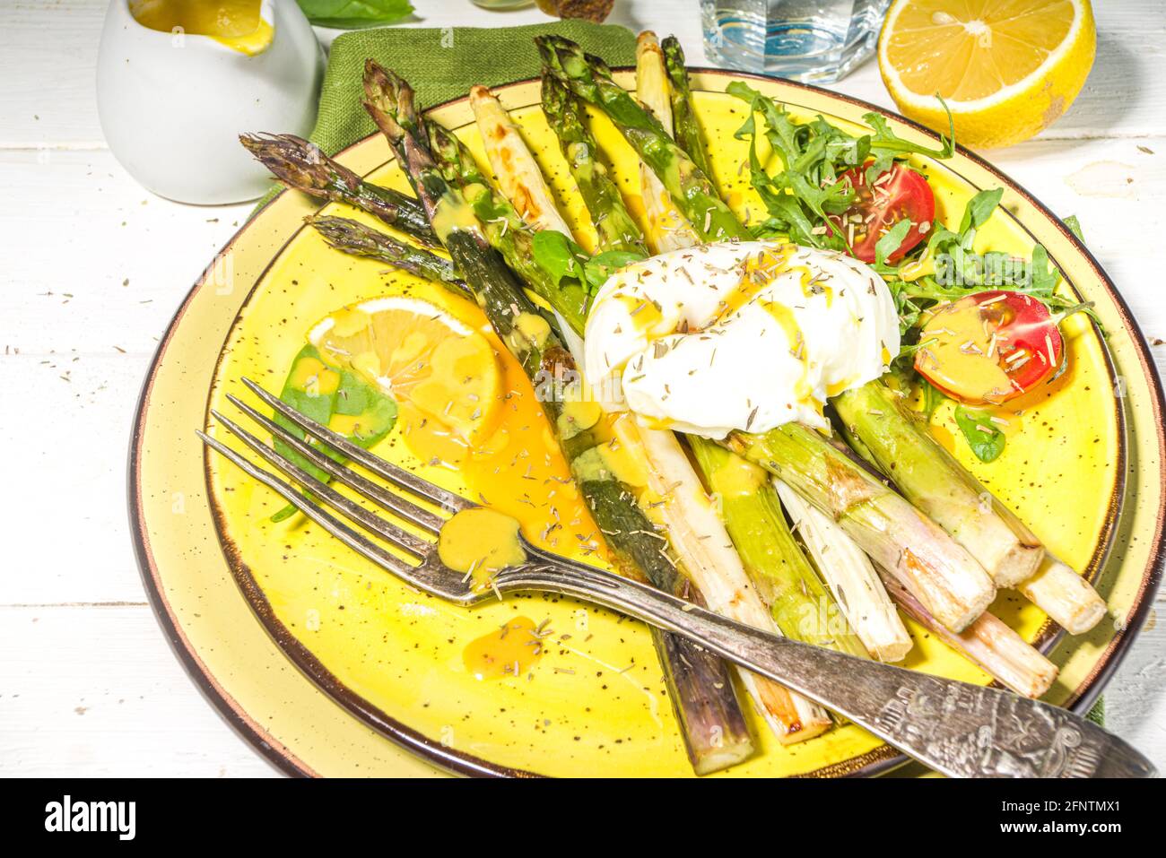 Nourriture saine, asperges grillées au four, œuf poché et sauce hollandaise sur fond de bois blanc espace copie vue du dessus Banque D'Images