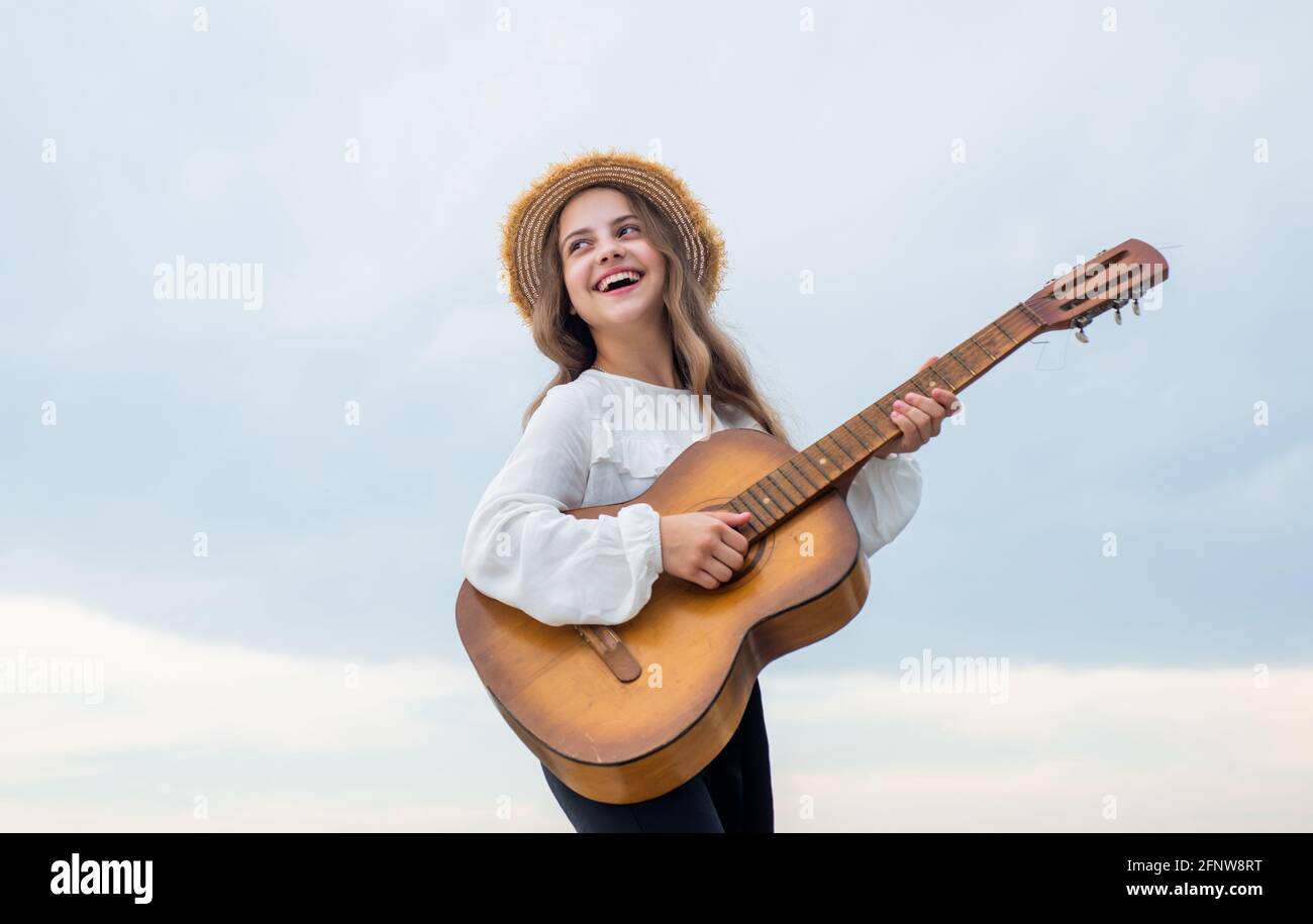 enfant fille élégante jouant de la guitare en plein air, vocal Banque D'Images