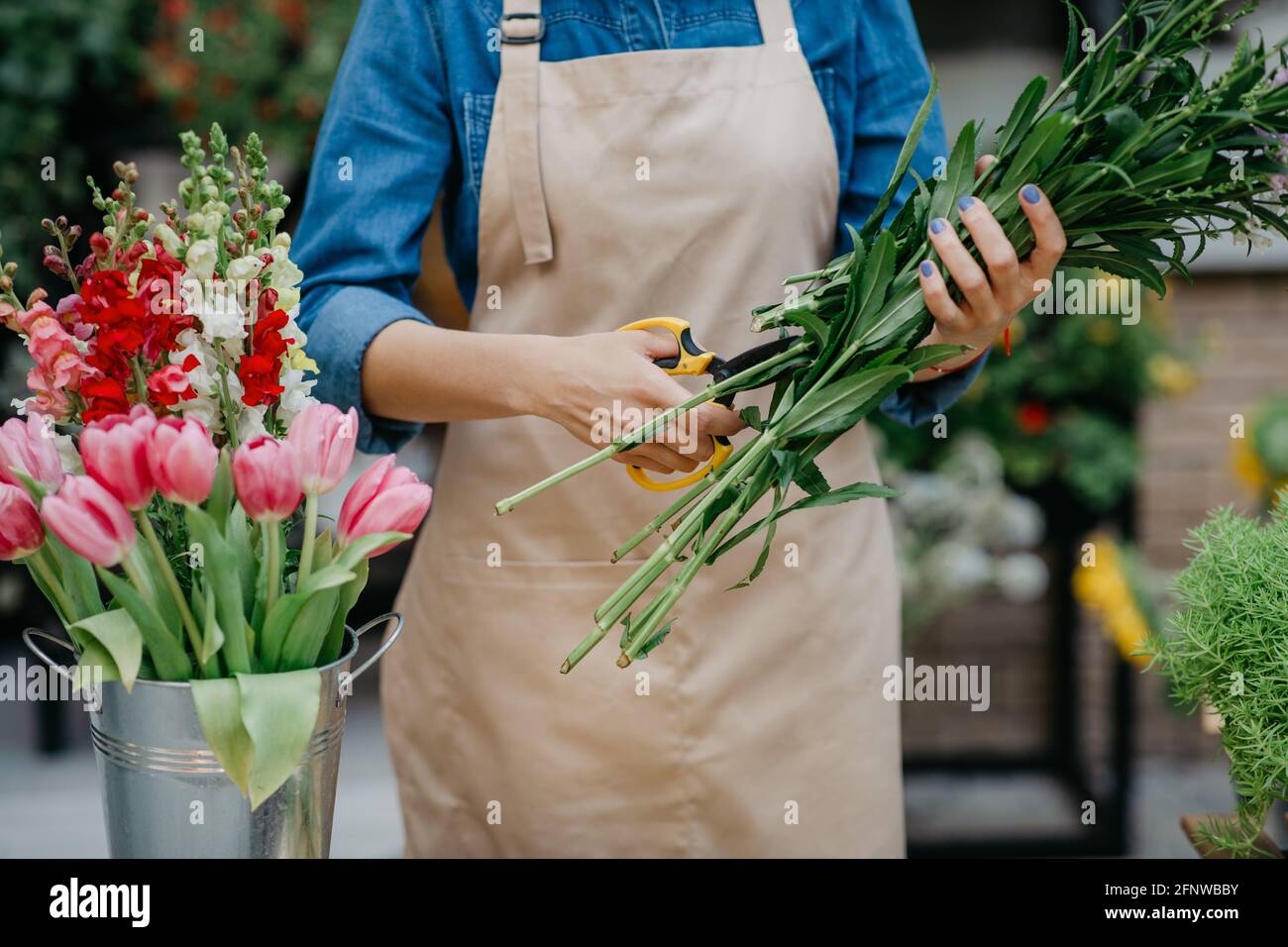 Concepteur de bouquets en studio de fleurs, fleuriste et vendeur à la boutique Banque D'Images