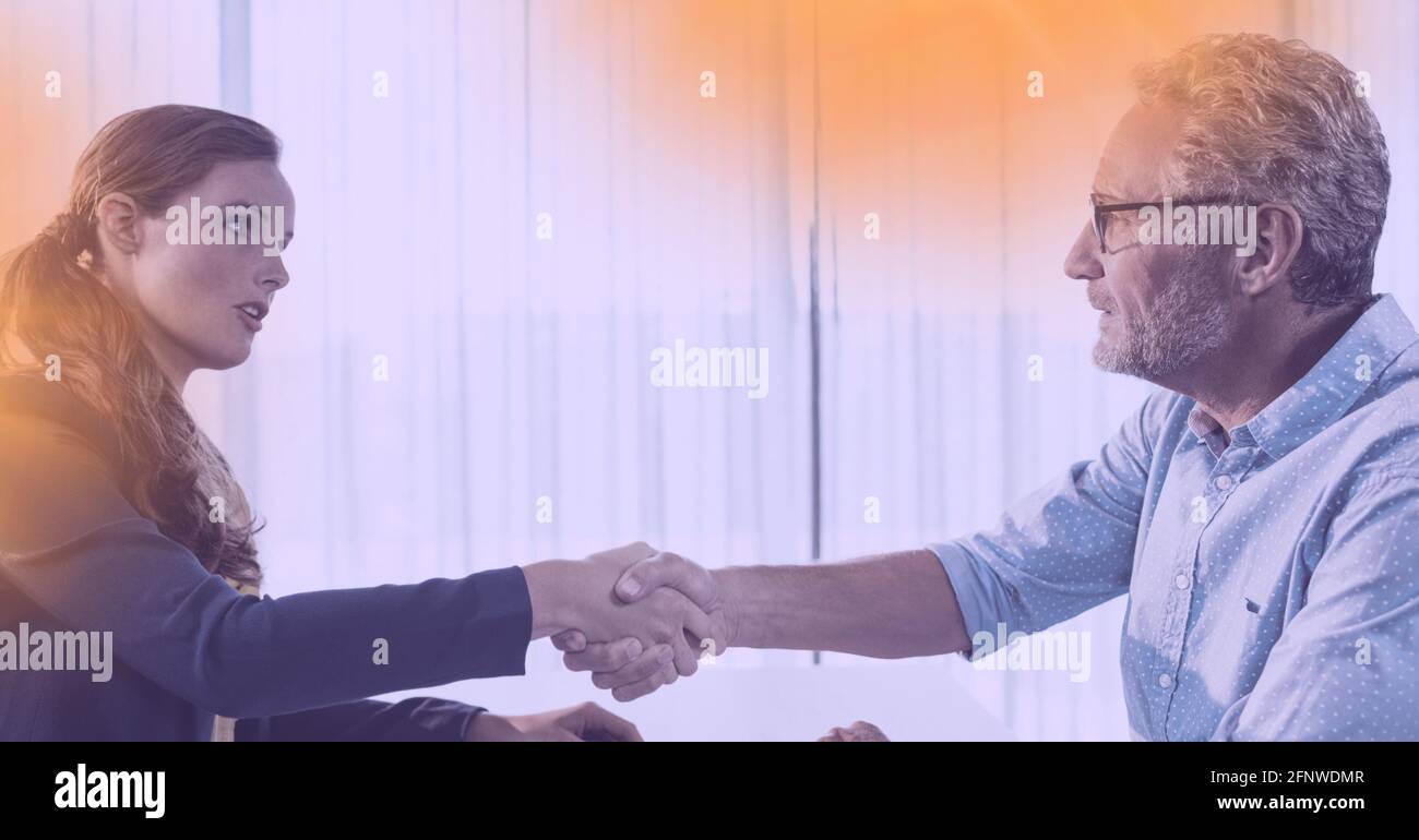 Composition de l'homme d'affaires et de la femme d'affaires qui se secouent la main au bureau Banque D'Images