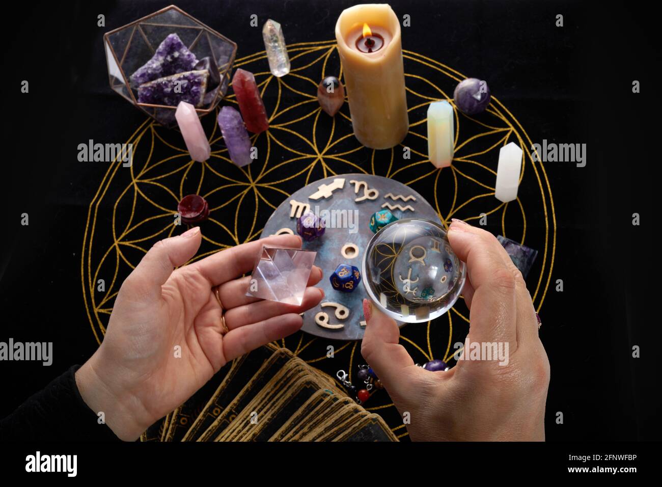 Table de la chance avec des objets ésotériques et main tenant boule de cristal. Banque D'Images