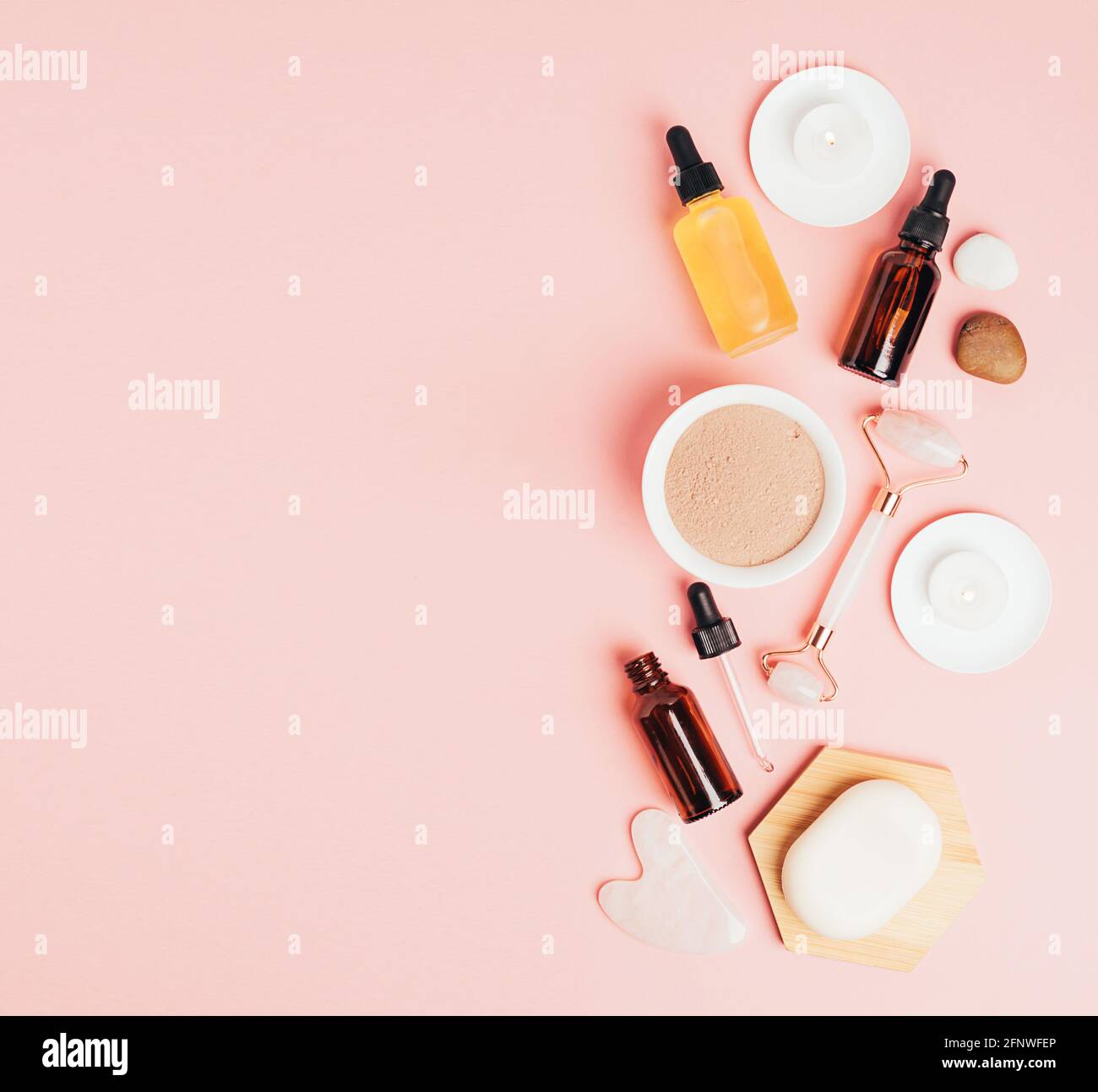 Composition spa sur fond rose pastel. Cosmétiques naturels bio bouteille d'huile, crème, argile, sel, outil de massage gua sha accessoires plan Banque D'Images