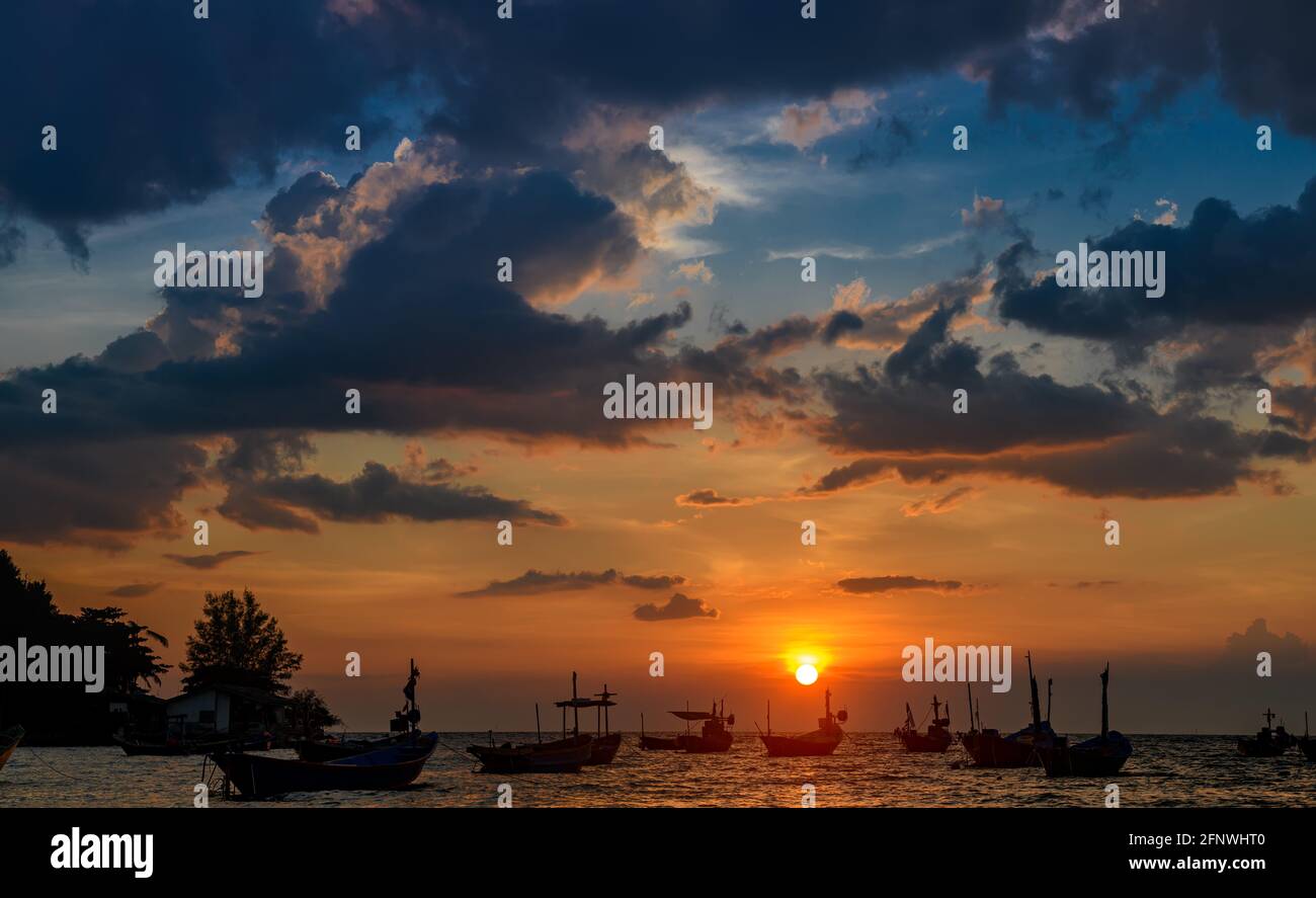 Bateaux de pêche Silhouette dans la mer avec coucher de soleil lumière chaude et ombre sombre. Banque D'Images