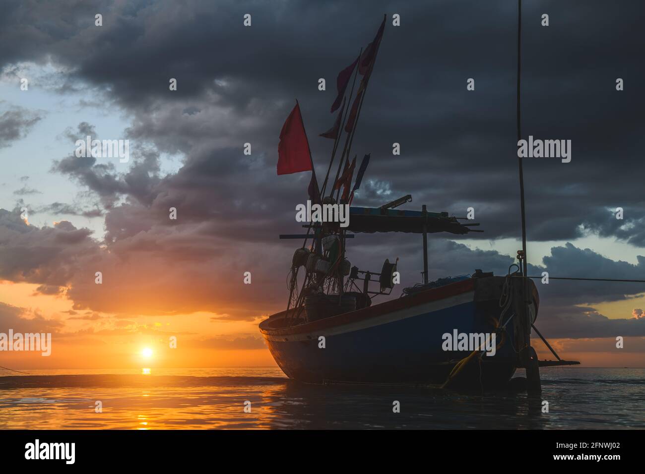 Bateaux de pêche Silhouette dans la mer avec coucher de soleil lumière chaude et ombre sombre. Banque D'Images