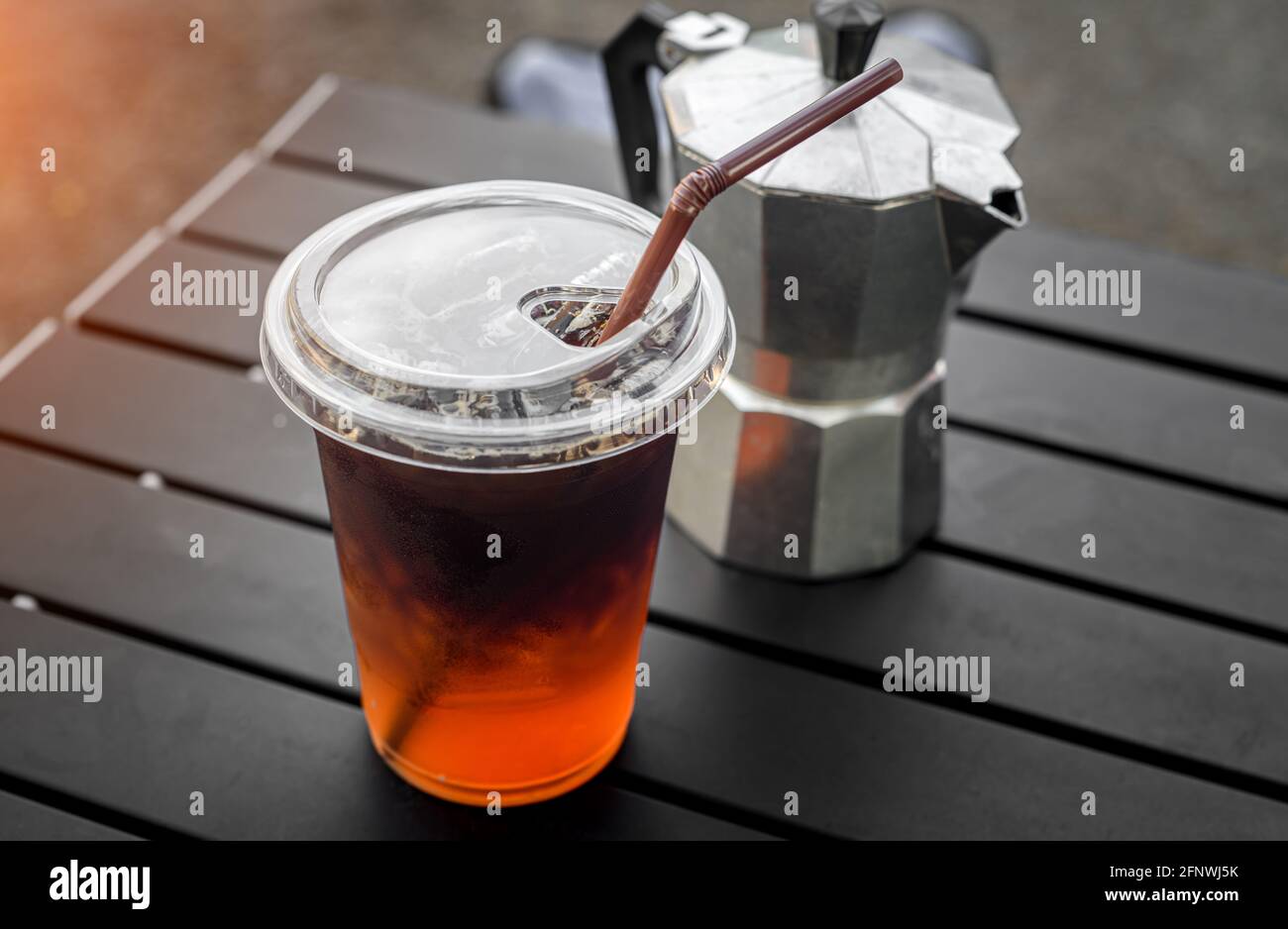 Café glacé americano en verre plastique de style asiatique Street Cafe avec éclairage extérieur. Banque D'Images