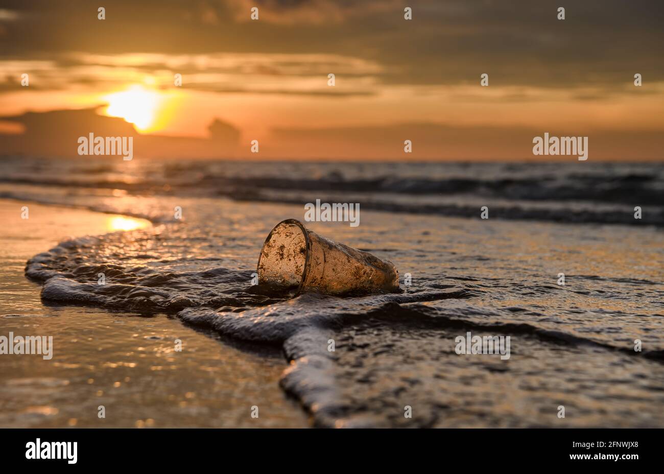Déchets de verre en plastique sur le rivage de la plage avec éclairage extérieur. Banque D'Images