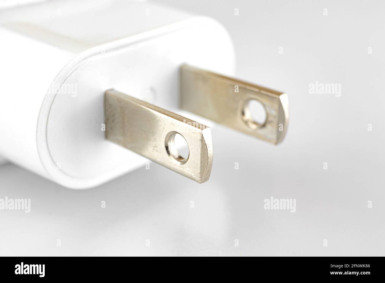 Adaptateur de charge blanc avec prise US photo en gros plan activée arrière-plan blanc et argent Banque D'Images