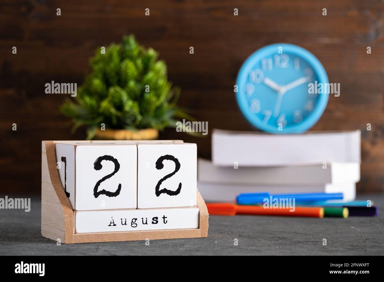 22 août. Août 22 calendrier cube en bois avec des objets flous sur fond. Banque D'Images
