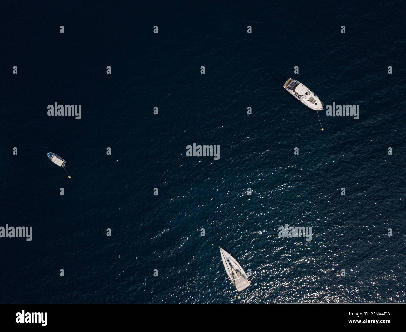 Vue aérienne des bateaux et des yachts amarrés au large de la côte du Monténégro, mer Adriatique bleu profond Banque D'Images