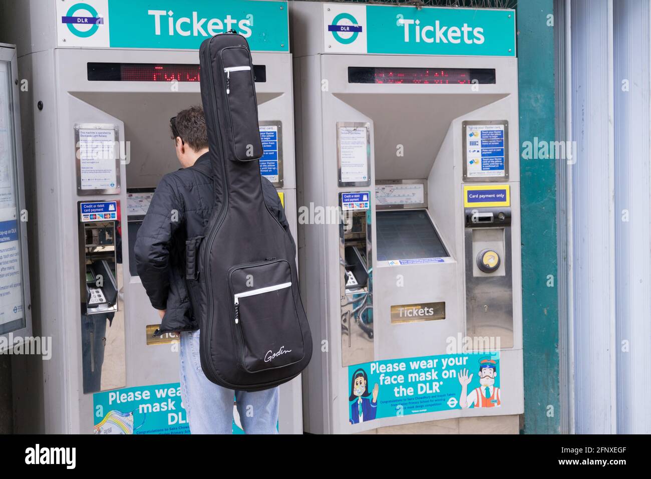 Homme achetant un billet à la machine à billets de train, DLR, dockland, Greenwich Banque D'Images