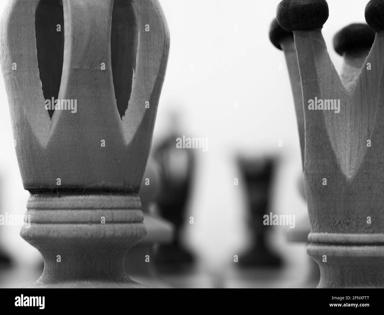 Pièces d'échecs. Gros plan sur les pièces d'échecs du roi et de la reine. Photographie en noir et blanc. Faible profondeur de champ. Des figures floues en arrière-plan. Banque D'Images
