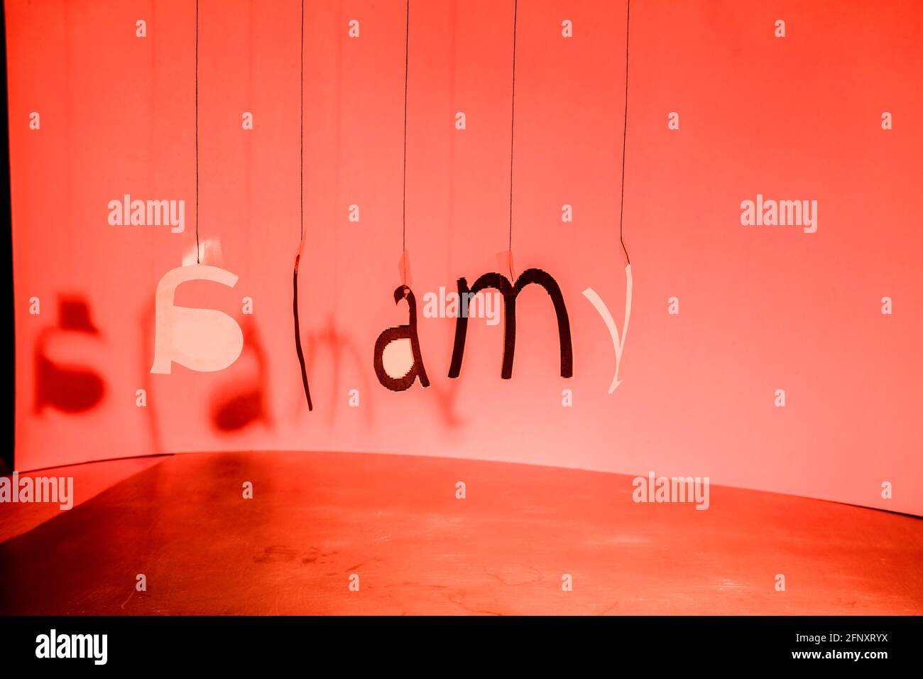 Les lettres accrochées à des fils forment, dans un certain désordre, le logo Alamy. Copier l'espace... Banque D'Images