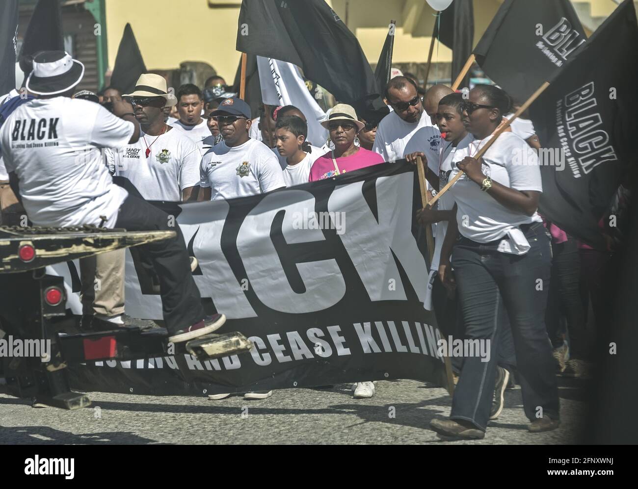 Belize City/Belize - 17 mars 2016 : manifestation contre la criminalité et la violence. Être aimant et cesser de tuer: NOIR. Personnes avec des signes et des drapeaux. Banque D'Images