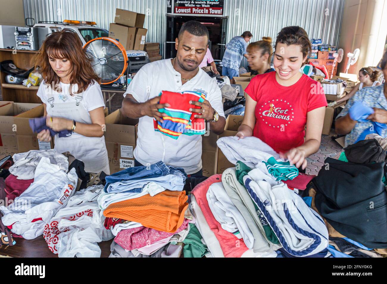 Florida Carol City Miami Hurricane relief bannière de dépôt, bénévoles dons hommes hispaniques noirs femmes triant vêtements donnés, Banque D'Images