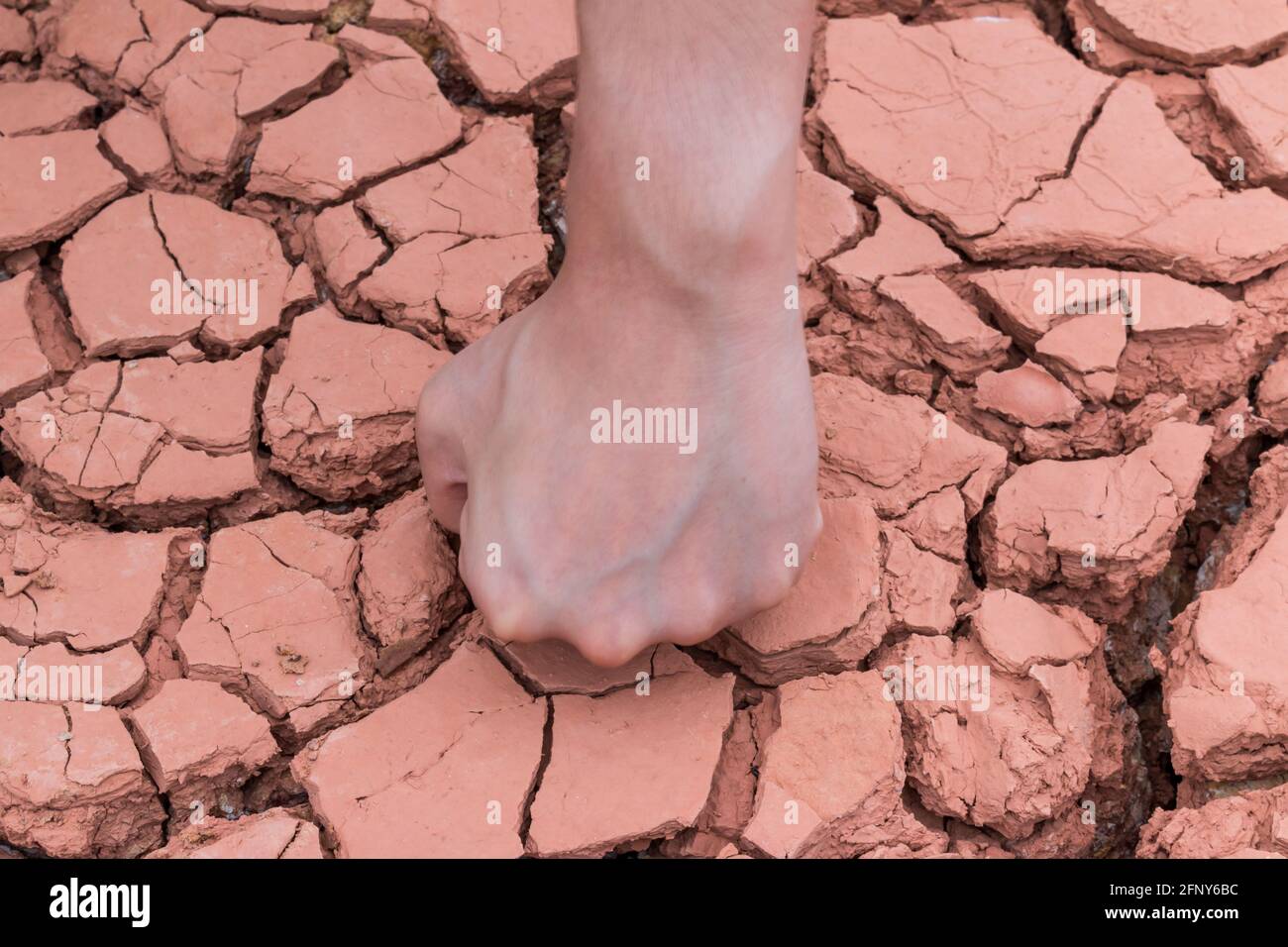 Mettre les mains sur un fond sec de terre/crack de terre Banque D'Images