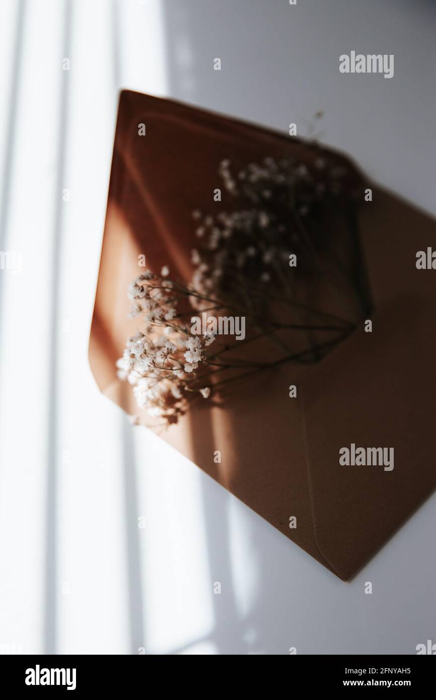 Enveloppe brune remplie de fleurs pour le mariage, l'anniversaire ou la remise des diplômes. Images d'humeur et de style de vie pour Instagram et Pinterest Banque D'Images