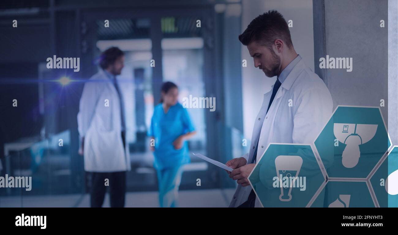 Spot de lumière et de multiples icônes médicales contre le médecin masculin utilisation d'une tablette numérique à l'hôpital Banque D'Images