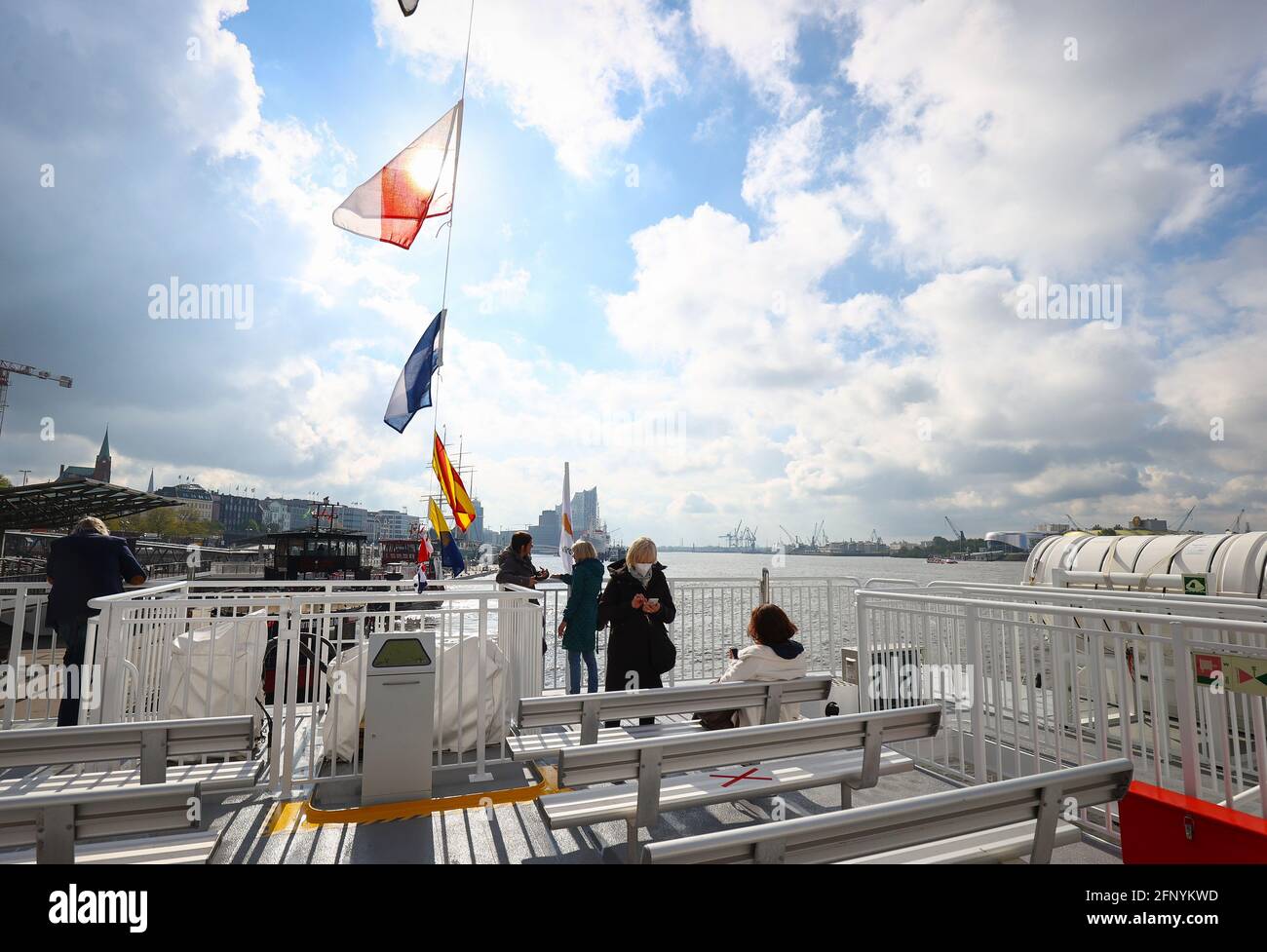 20 mai 2021, Hambourg : les passagers se tiennent sur le pont du ferry à grande vitesse Halunder Jet peu avant qu'il ne quitte les étapes de l'atterrissage pour un voyage à Helgoland. Le catamaran Helgoland a commencé la nouvelle saison jeudi matin. La saison devait commencer le 26 mars, mais elle a été reportée en raison de la pandémie de Corona. Le bateau navigue maintenant tous les jours de nouveau de Hambourg et Cuxhaven à l'île de la mer du Nord. Photo: Christian Charisius/dpa Banque D'Images