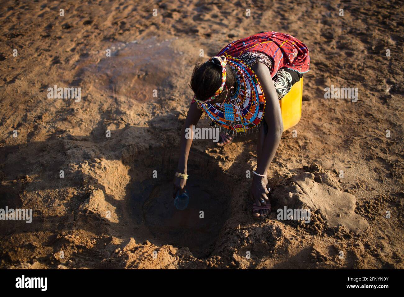 Le 19 février 2015, une femme recueille de l'eau filtrée nettoyée dans un trou creusé près d'une rivière près du village d'Umoja à Samburu, au Kenya. Banque D'Images