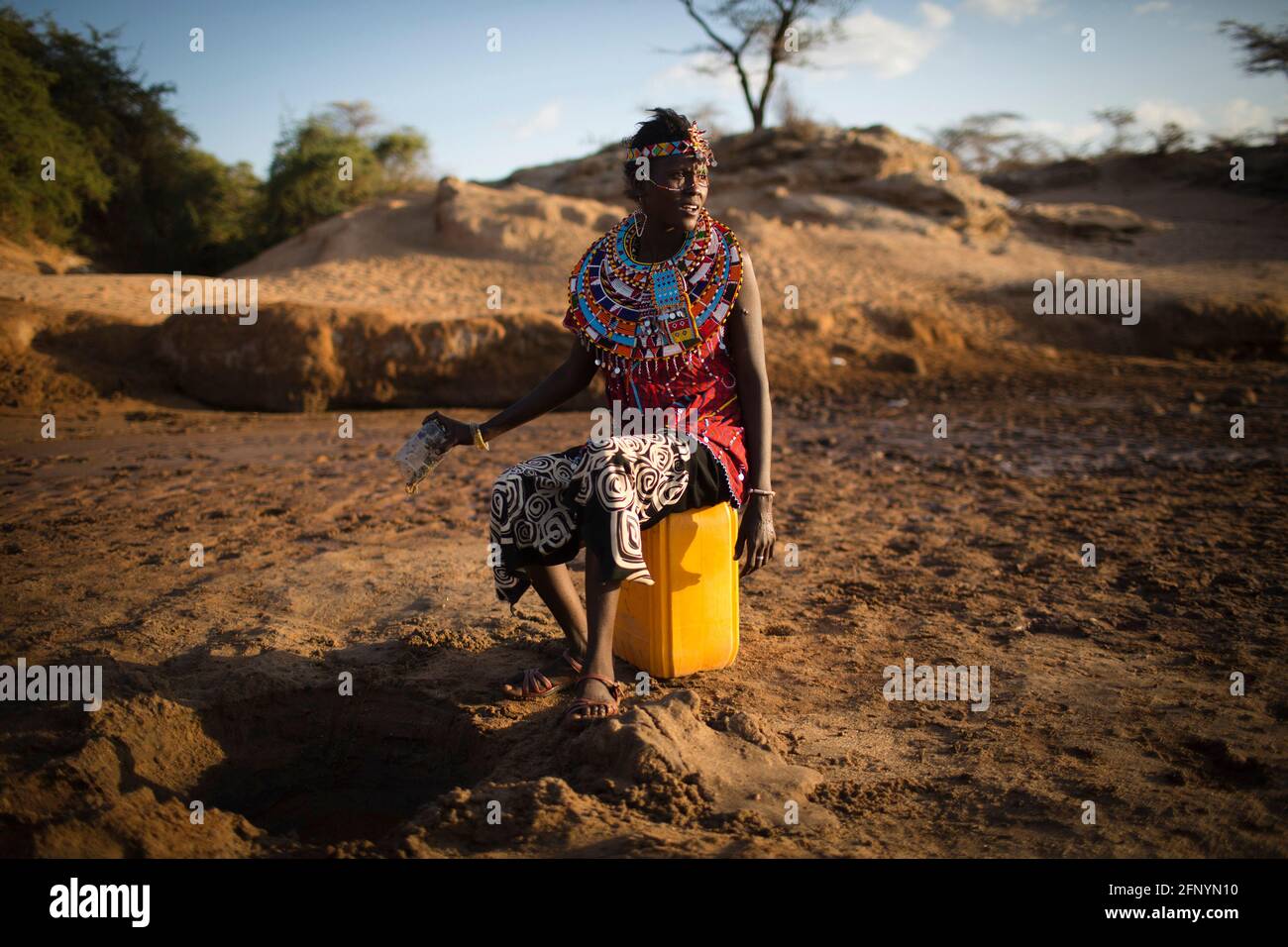 Le 19 février 2015, une femme recueille de l'eau filtrée nettoyée dans un trou creusé près d'une rivière près du village d'Umoja à Samburu, au Kenya. Banque D'Images