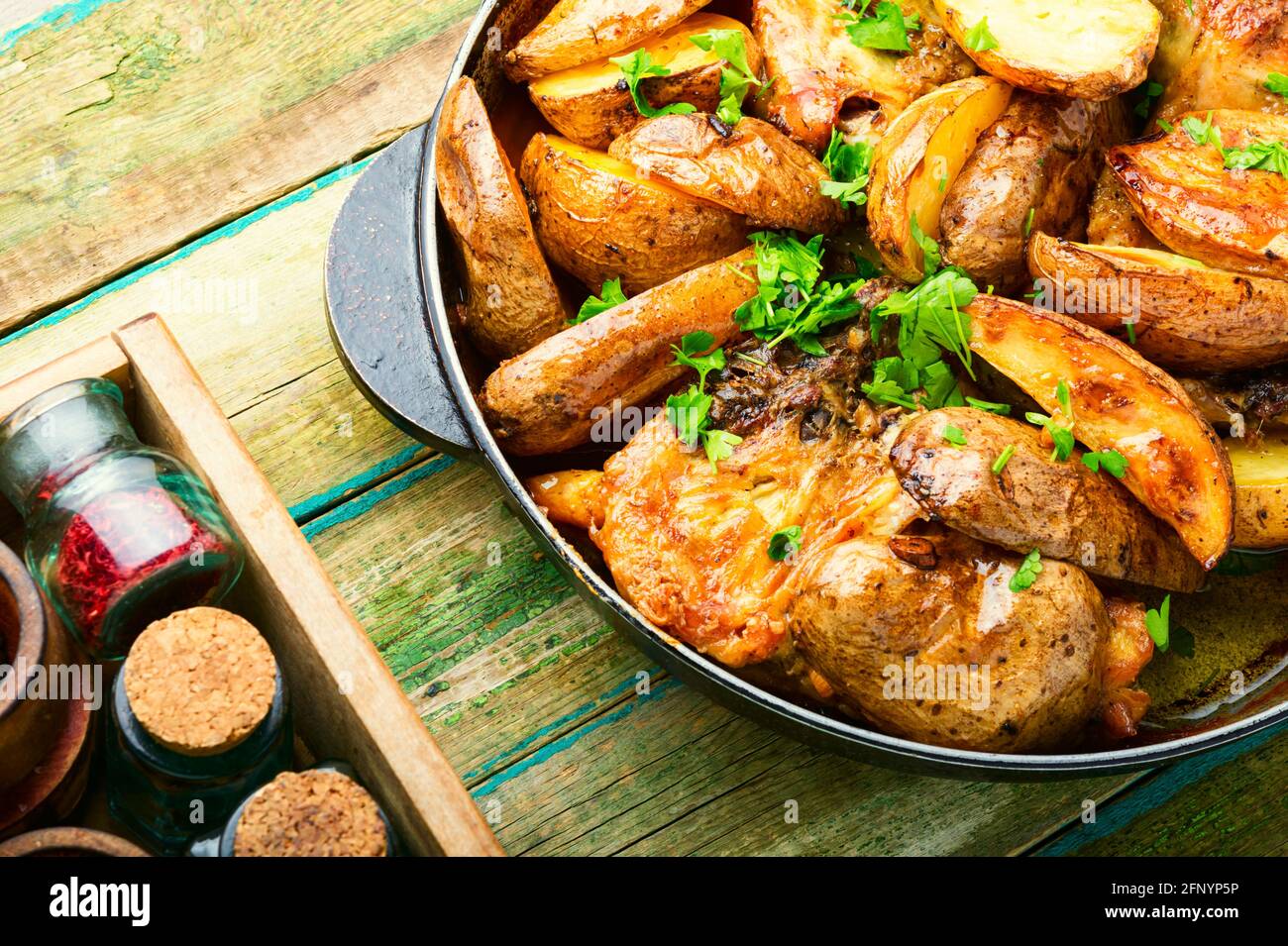 Appétissant viande de poulet avec des pommes de terre rôties dans une poêle. Morceaux de poulet cuit avec des légumes Banque D'Images