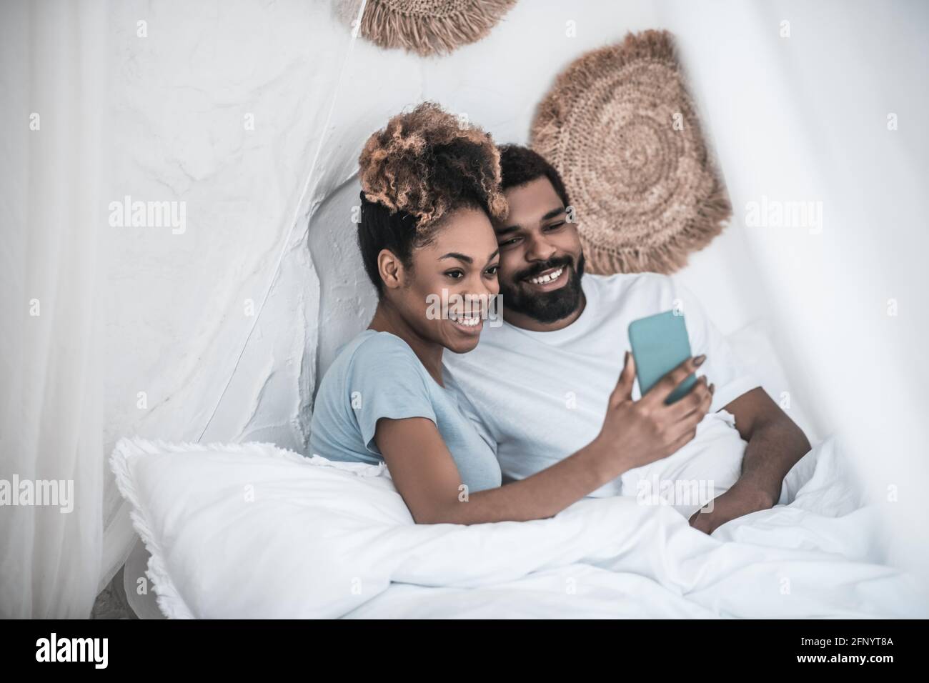 Darkskined femme et homme prenant le selfie au lit Photo Stock - Alamy