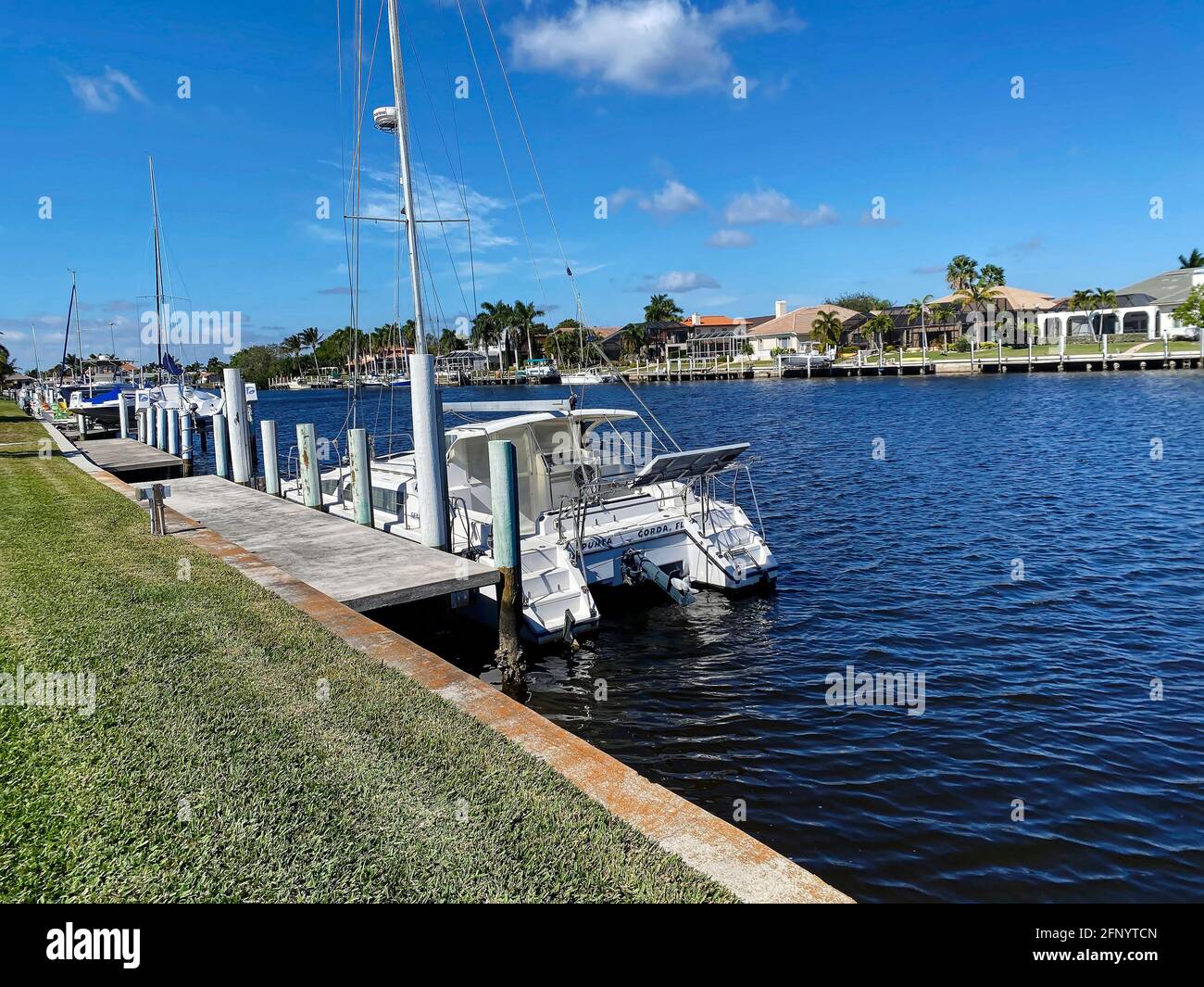 scène du canal; quais; bateaux; maisons; eau bleue; Herbe; palmiers; style de vie, Floride, Punta Gorda; FL Banque D'Images