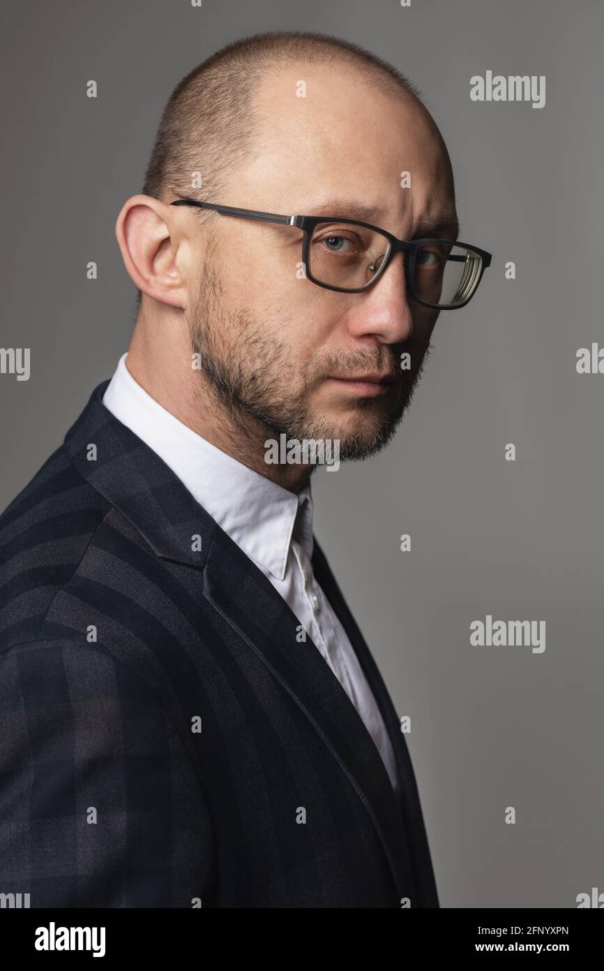 Portrait d'un homme avec un look pensif dans un costume et des lunettes. Banque D'Images