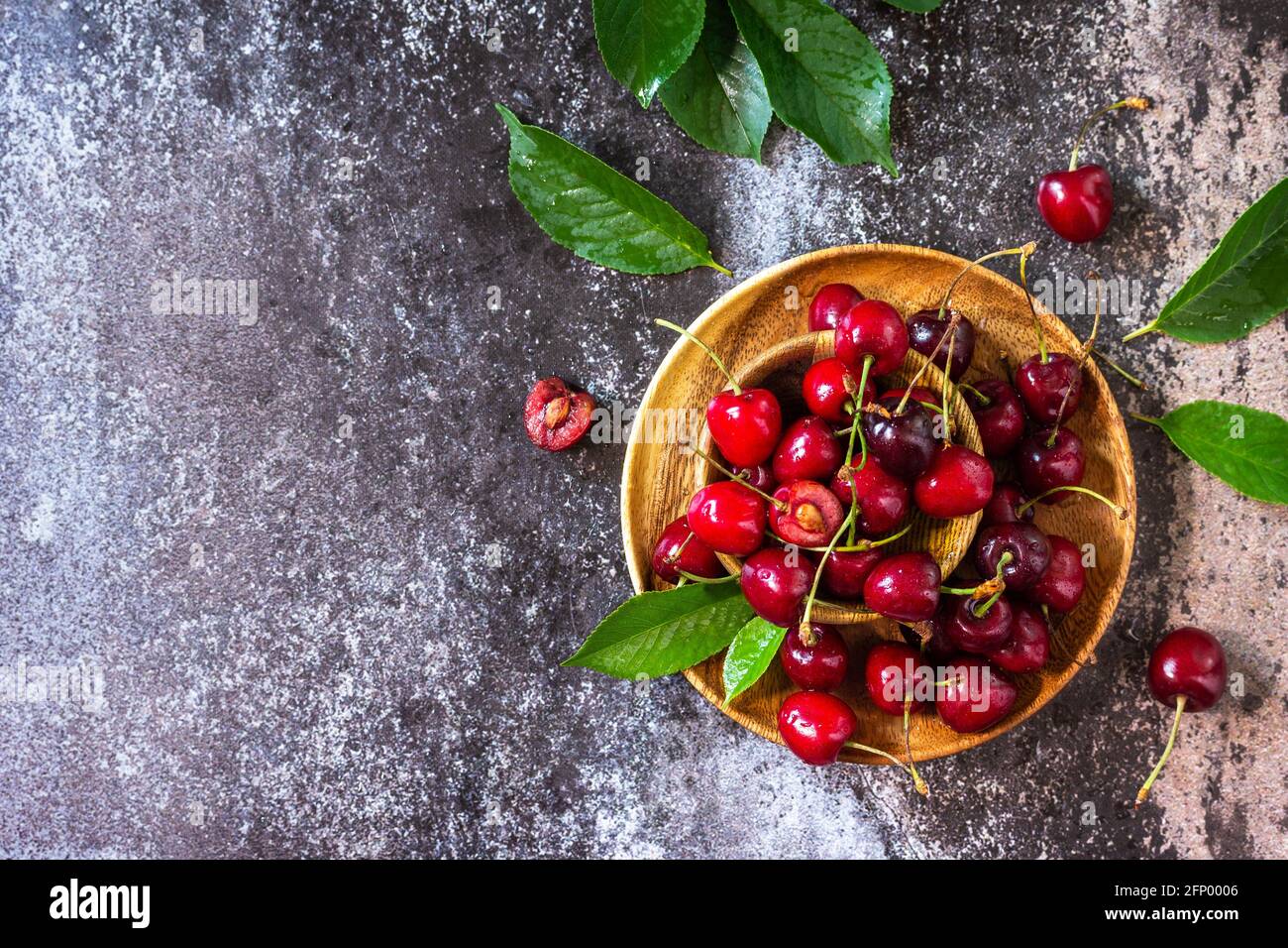 Fruits frais mûrs bio. Cerise rouge sucrée sur une assiette sur un plan d'examen en pierre sombre. Vue de dessus de l'arrière-plan de la mise à plat Copier l'espace. Banque D'Images