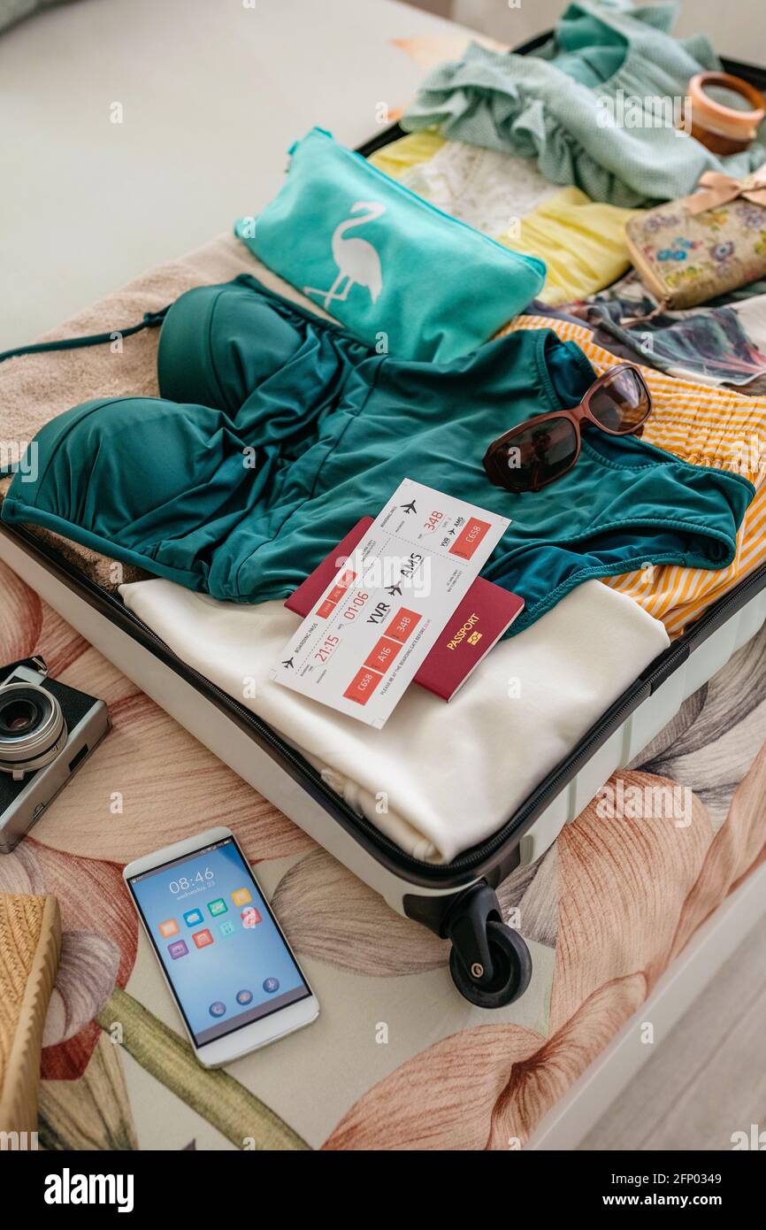 Une valise femme ouverte est préparée pour les vacances d'été Photo Stock -  Alamy