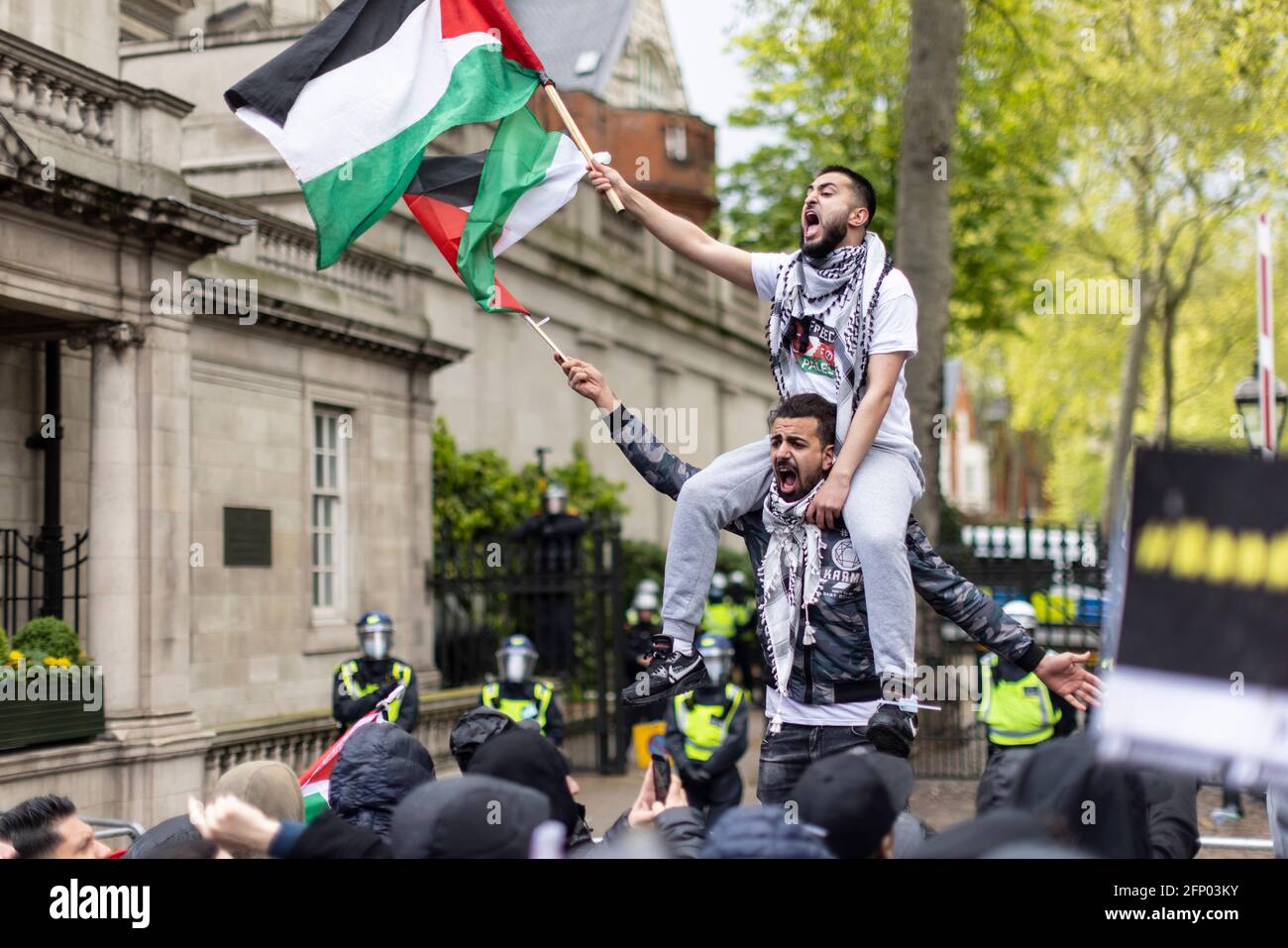 Un manifestant s'assoit sur les épaules d'un autre et crie, manifestation de solidarité "Palestine libre", Londres, 15 mai 2021 Banque D'Images