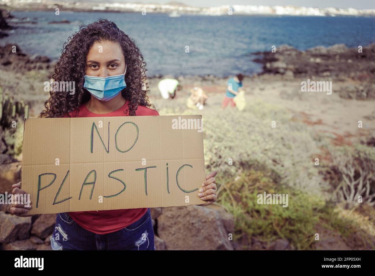 Groupe de militants avec des bannières protestant contre la pollution sur la côte. Les adolescents protestent sans bruit contre une société consciente. Femme tenant une bannière Banque D'Images