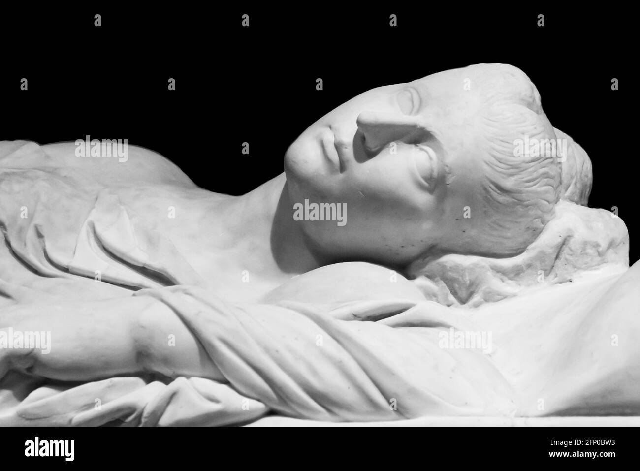 Photo en noir et blanc de l'ancienne sculpture romaine en gros plan montrant le visage d'une femme dormant sur son tombeau Banque D'Images