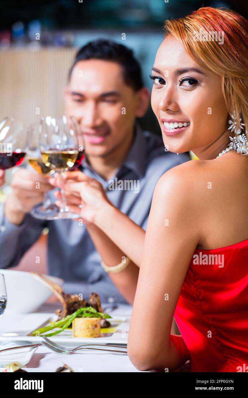 Les amis de l'Asie, deux couples, dîner dans un restaurant de fantaisie manger de la bonne nourriture et de boire du vin Banque D'Images